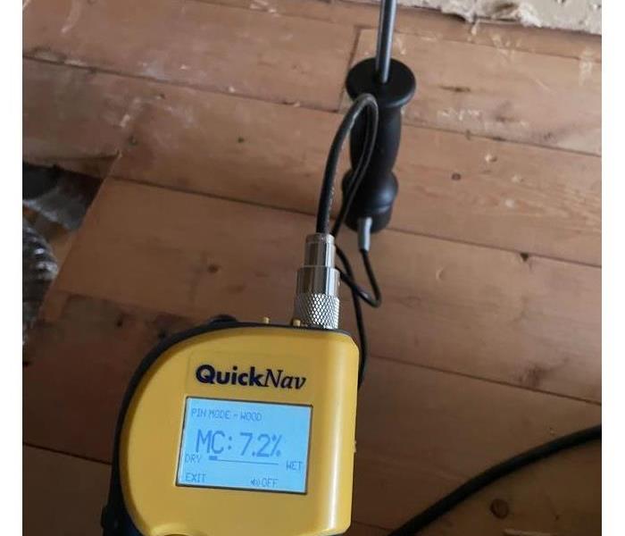 Moisture Detecting probe taking a reading from a wet wood subfloor.
