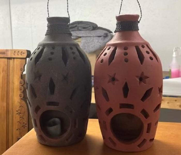 Two ceramic lanterns one covered in soot and the other cleaned to like-new condition.
